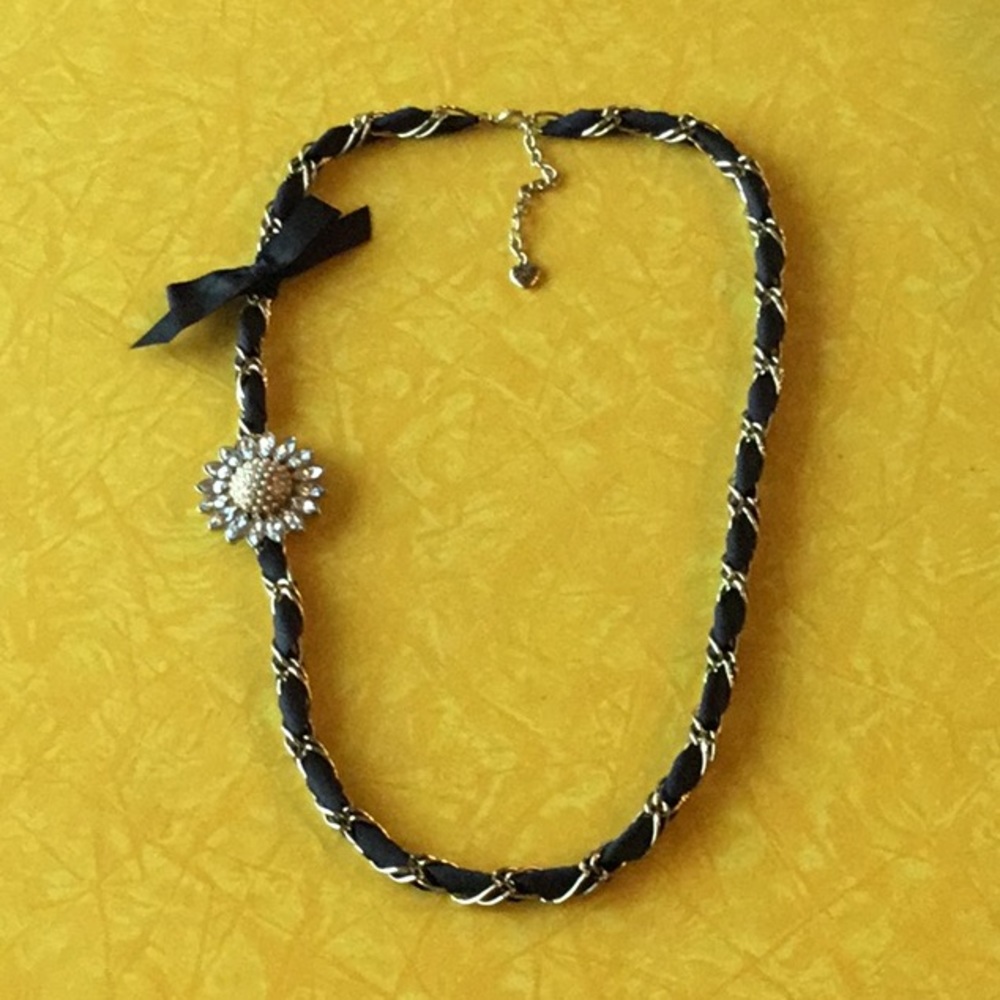 Betsey Johnson necklace with rind-stone daisy and black ribbon.